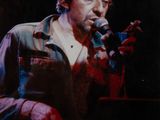 an old photo of a man holding a microphone in front of a microphone
