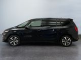 a black minivan parked in a room with a white wall