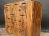 an image of a wooden chest of drawers on a carpeted floor