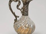 un pichet ancien en argent et en verre sur fond blanc