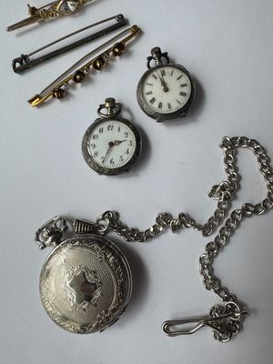 a silver pocket watch with a chain around it