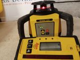 a yellow and black laser level with a red light on it