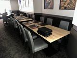 a long table with many chairs and a laptop on it