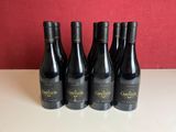 six bouteilles de vin rouge sont alignées sur une table