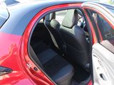 a red car with its door open in a parking lot