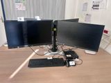 two computer monitors and a keyboard on a desk