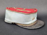 un chapeau blanc orné d'un ruban rouge
