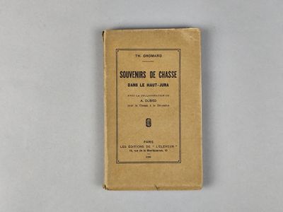 un vieux livre posé sur une table à côté d'un mur blanc