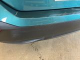 the rear end of a blue car with a sticker on it ' s bumper