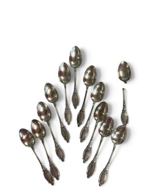 six spoons are arranged in a circle on a white surface