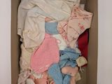 a cardboard box filled with clothes and baby items