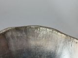 a silver bowl with a handle on a table