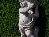 a statue of a boy holding a bird in his arms
