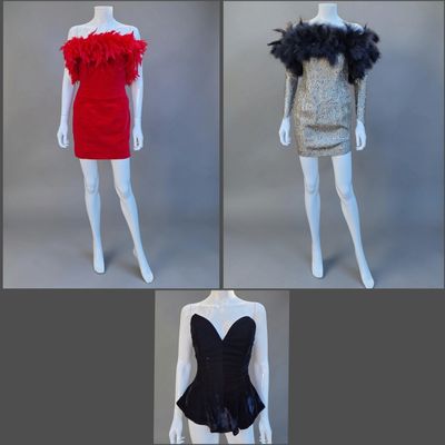 quatre mannequins vêtus de tenues de styles variés, ornés de plumes