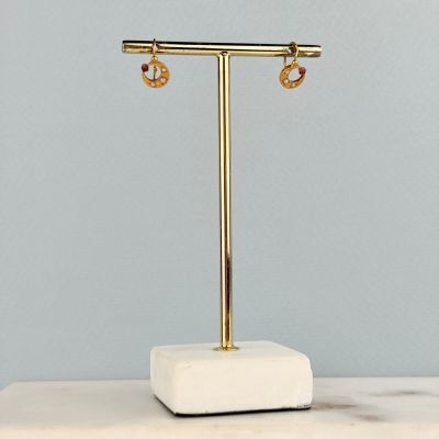 un gros plan sur une paire de boucles d'oreilles posées sur un présentoir sur une table