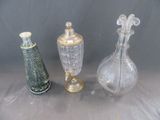 trois vases en verre posés l'un à côté de l'autre sur une table