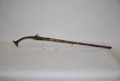 an old gun with a wooden handle on a white surface