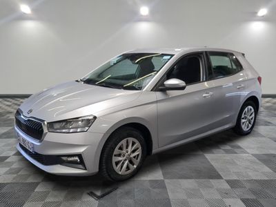 Une voiture argentée est garée dans une pièce au sol carrelé en damier.