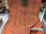 une écharpe à motif paisley orange et noir exposée dans un magasin