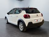 the rear of a white car is parked in a large room