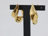 a close up of a pair of gold earrings on a black stand