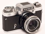 a black and silver camera sitting on a white surface