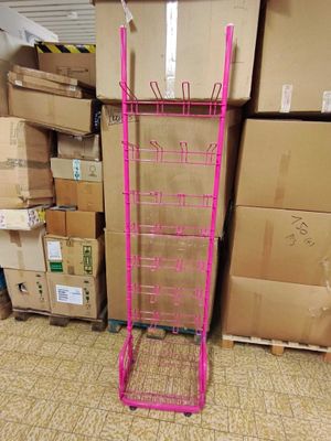 a pink rack with a pink handle in front of a pile of boxes
