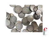 a pile of silver coins on a white surface