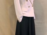 une veste blanche et une jupe noire sur un mannequin