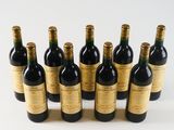 six bottles of wine are lined up in a row on a white surface