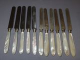 six knives are lined up in a row on a table