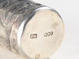 a close up of a silver object on a white surface