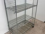 wire mesh shelf with four shelves on wheels in a room
