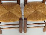 two wooden chairs that are sitting next to each other