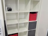 a white bookcase with many different colored bins