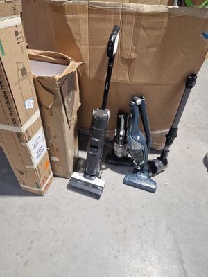 une pile de cartons et un aspirateur par terre
