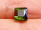 Des tourmalines vertes sont tenues dans la main d'une personne