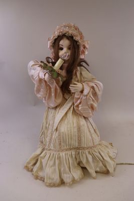 une statue représentant une femme en robe et coiffe, tenant une banane