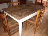 a table and chairs in a room with wood flooring
