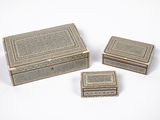 trois petites boîtes argentées posées les unes à côté des autres sur une surface blanche