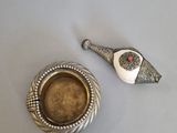 assiette en argent représentant un oiseau et un bol de soupe posés sur une table