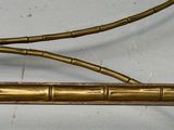 a gold metal bed frame with a bamboo headboard and foot board