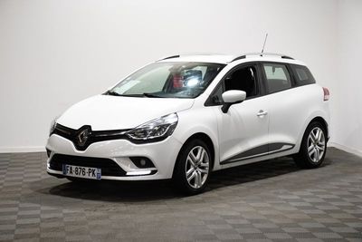 La voiture blanche est garée sur le sol à damier de la pièce.