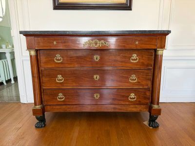 a picture of a dresser in a room with a painting on the wall