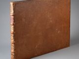 un vieux livre à la couverture brune posé sur une table