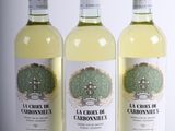 trois bouteilles de vin blanc posées les unes à côté des autres sur une table