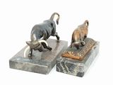 two statues of animals that are standing on marble blocks