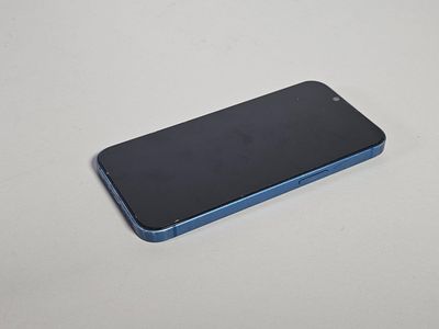 un gros plan d'un iPhone bleu posé sur une surface blanche