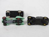 two toy cars sitting next to each other on a white surface