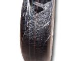 a piece of plastic wrapped around a tire on a white surface